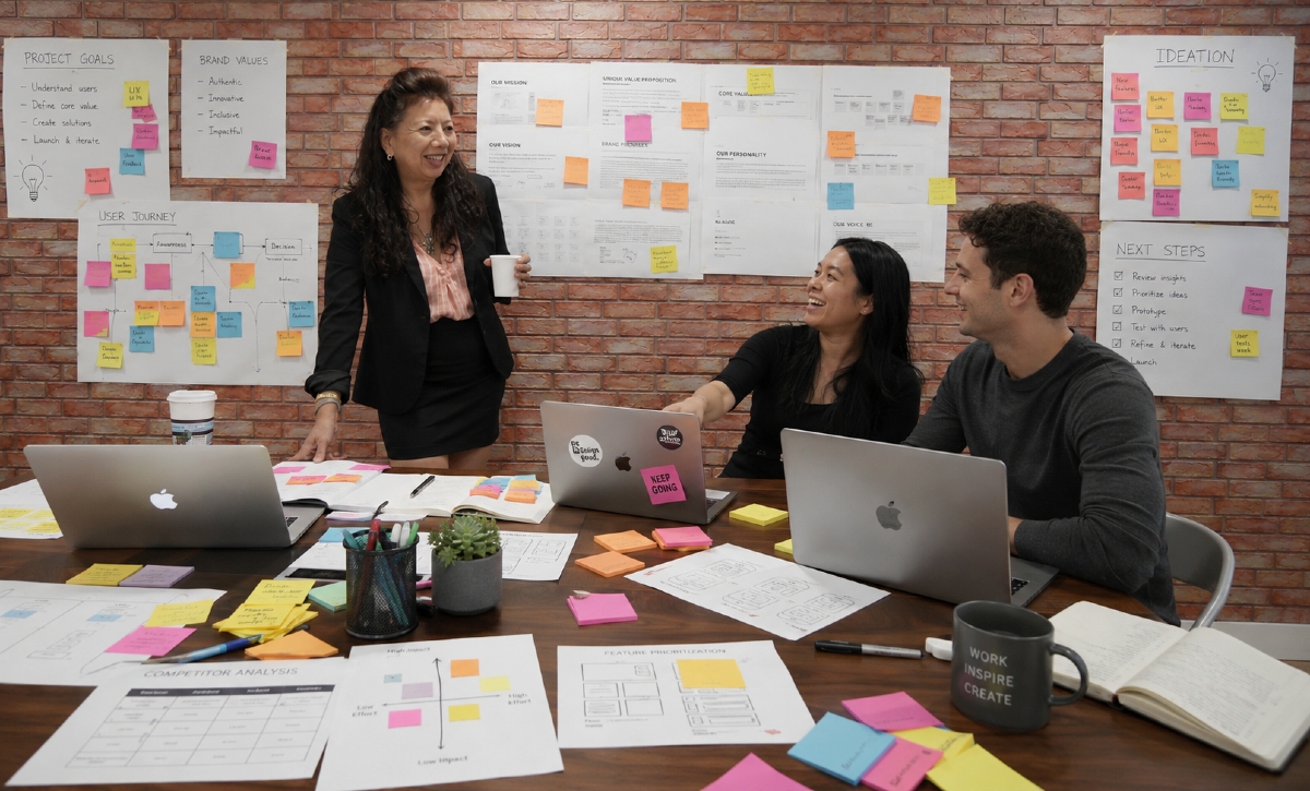 Two woman and one man brainstorming a a boardroom. the